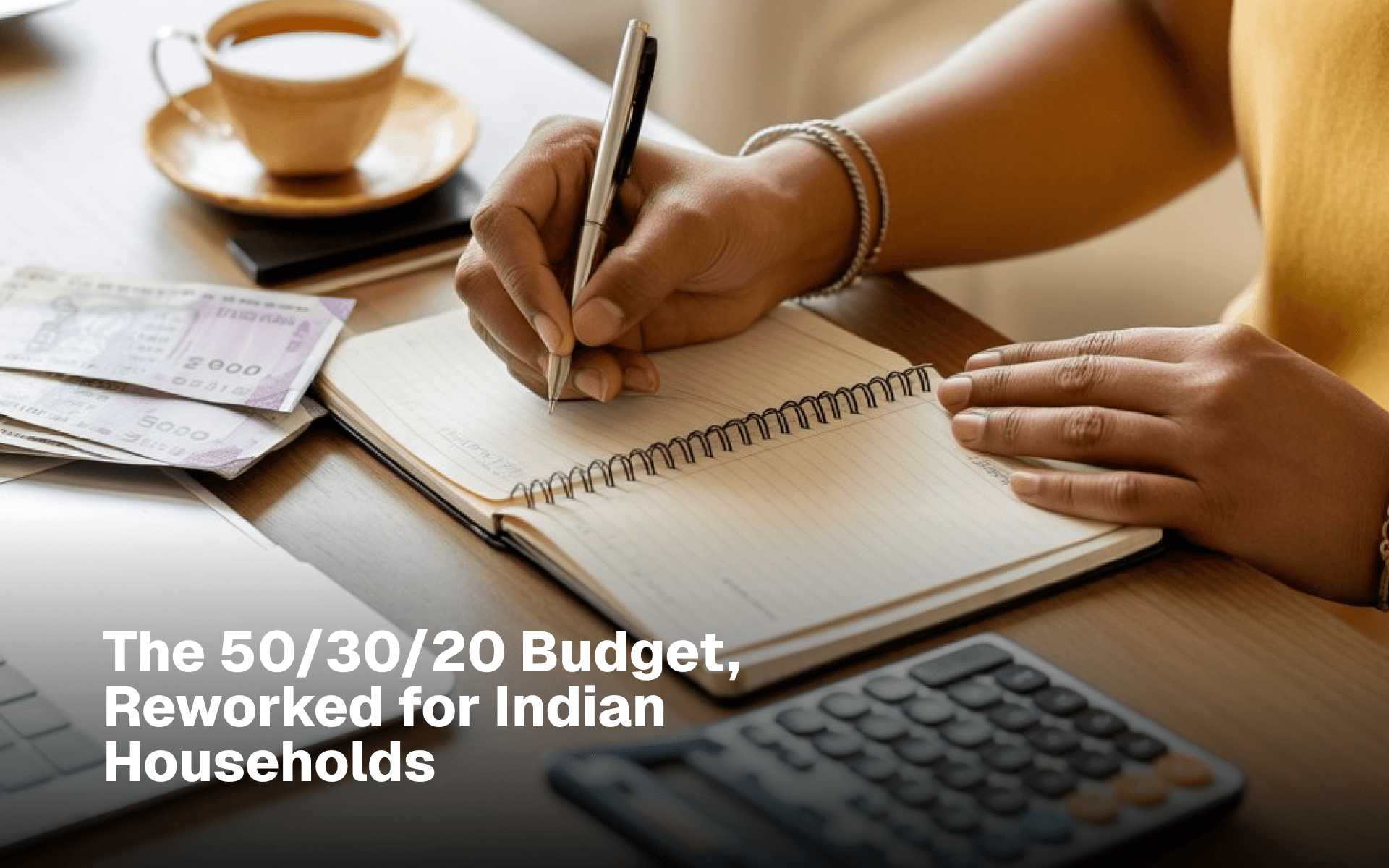 Person writing in a budget notebook beside Indian rupee notes and a calculator